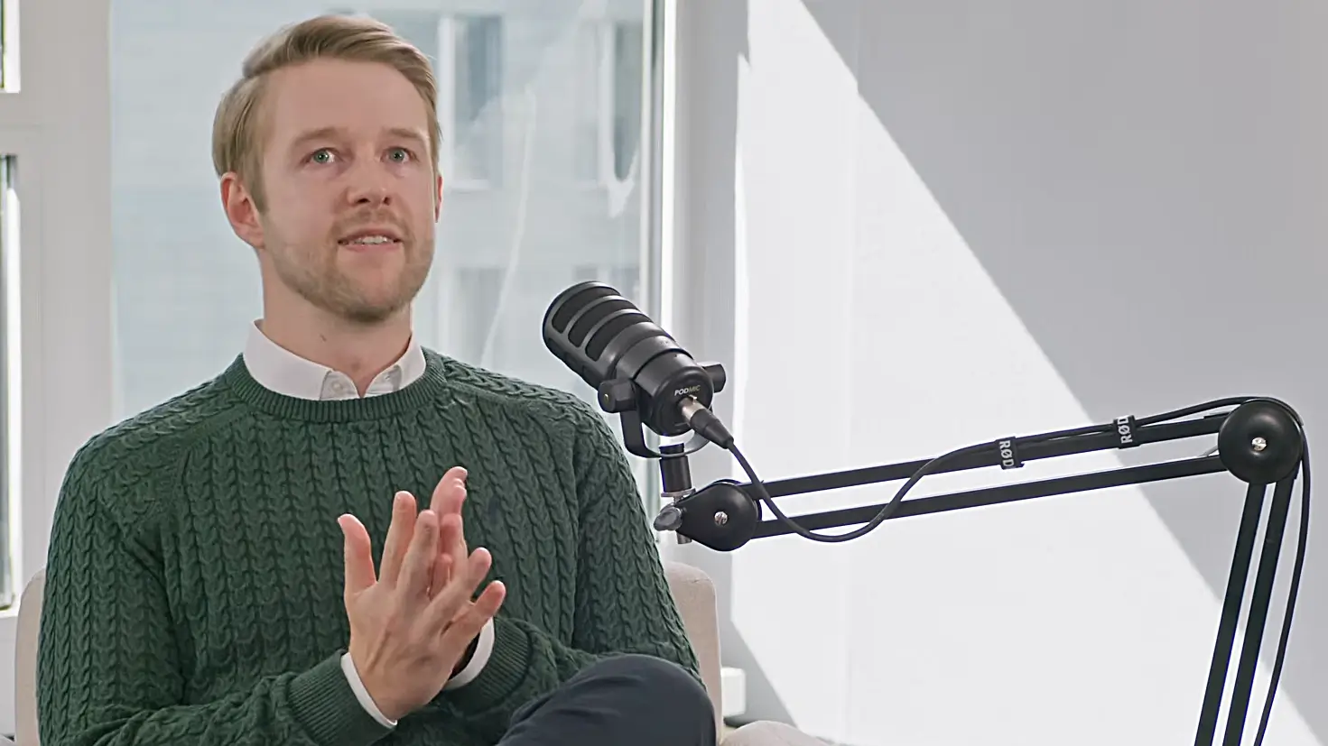 David Rissmann speaking next to a podcast microphone